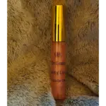 Elixian Essence lip gloss in a sleek bottle with an applicator, standing upright with label visible