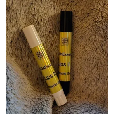 Elixian Essence Lips II pocket-sized lip balm in black and white tubes, side by side for comparison